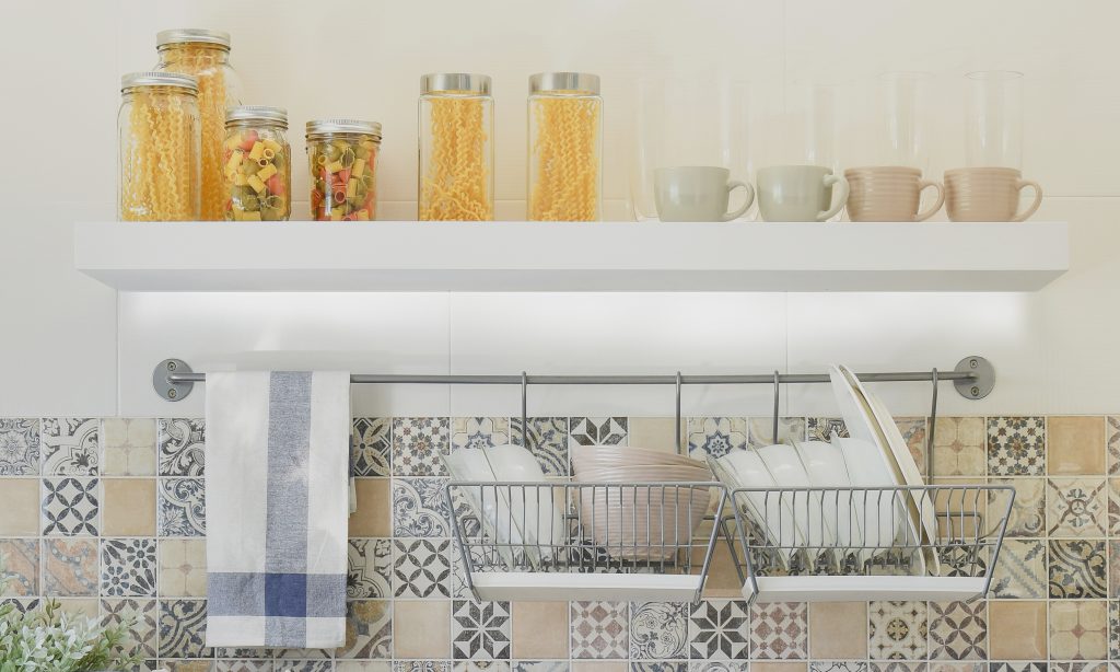 modern kitchen with ceramic kitchenware and utensils on the shelf