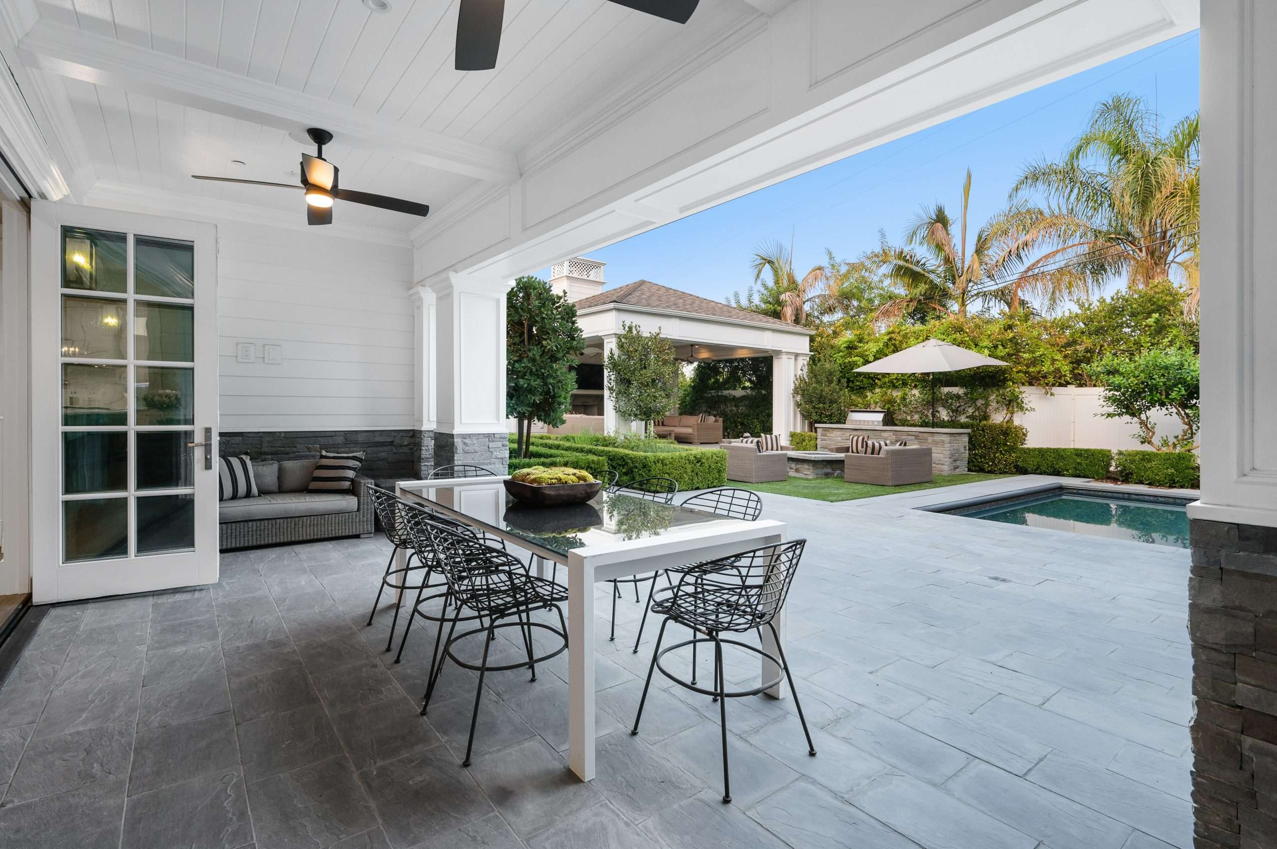Poolside patio with outdoor dining table in a new construction home in Encino, California