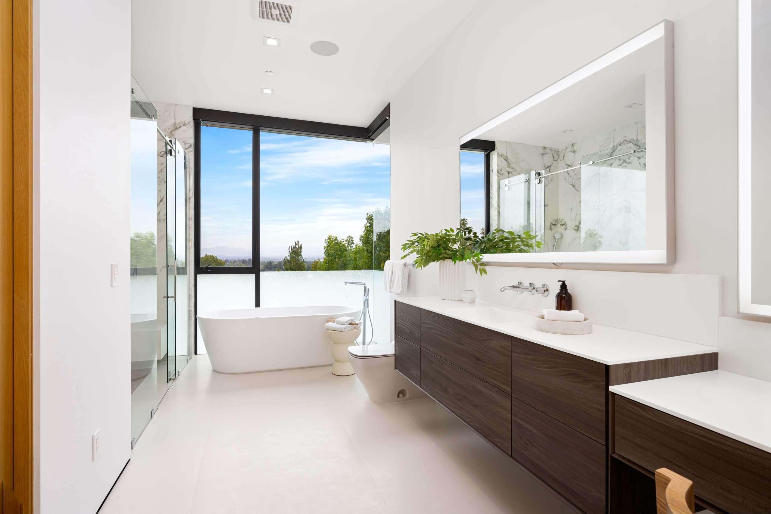 Spacious white bathroom with a sunny day view through the window