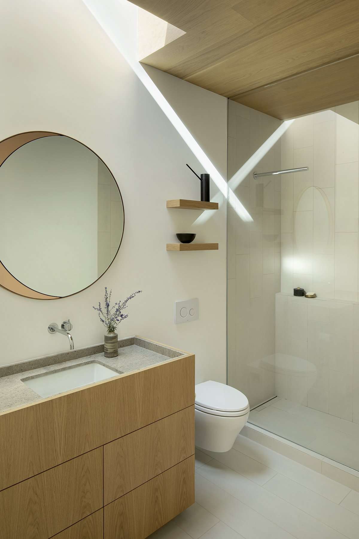 Bathroom with skylight, vanity, and shower