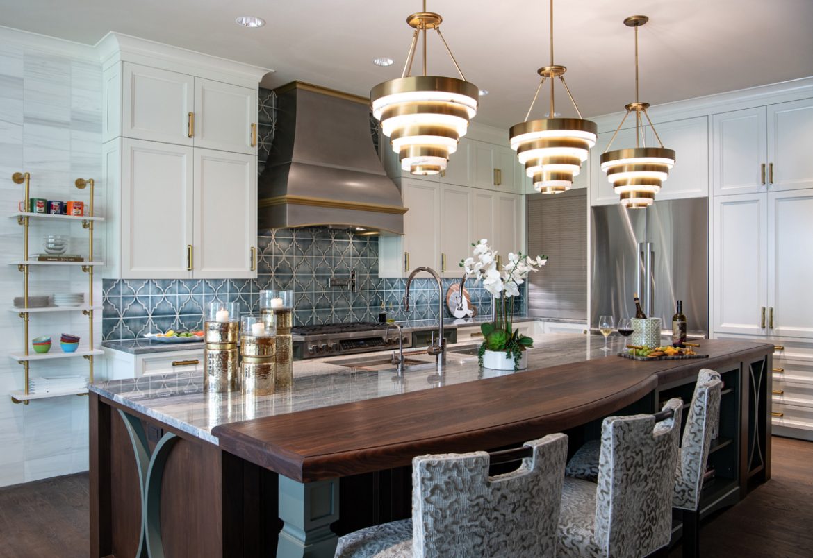 Modern kitchen with large island, pendant lights, and geometric tiled backsplash.