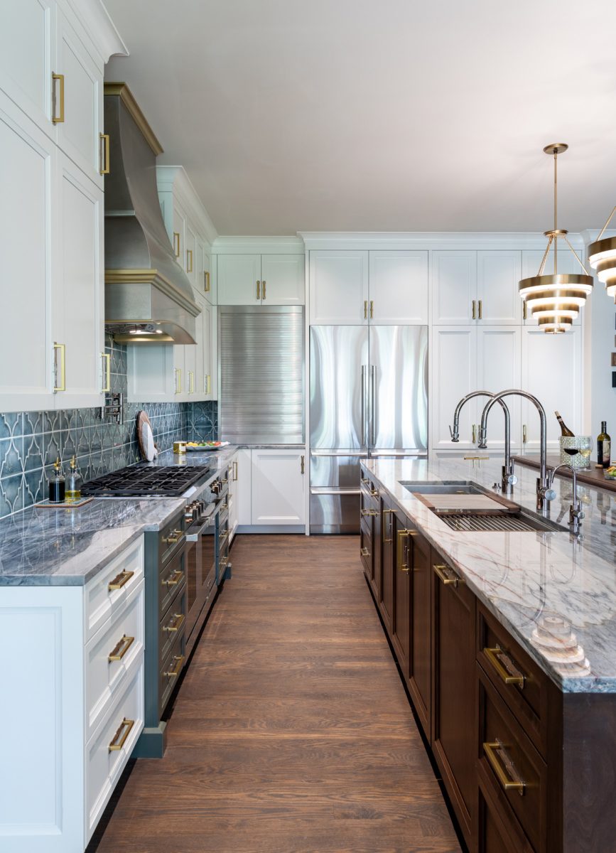 Modern kitchen with white cabinetry, marble countertops, and a large island with double sink.