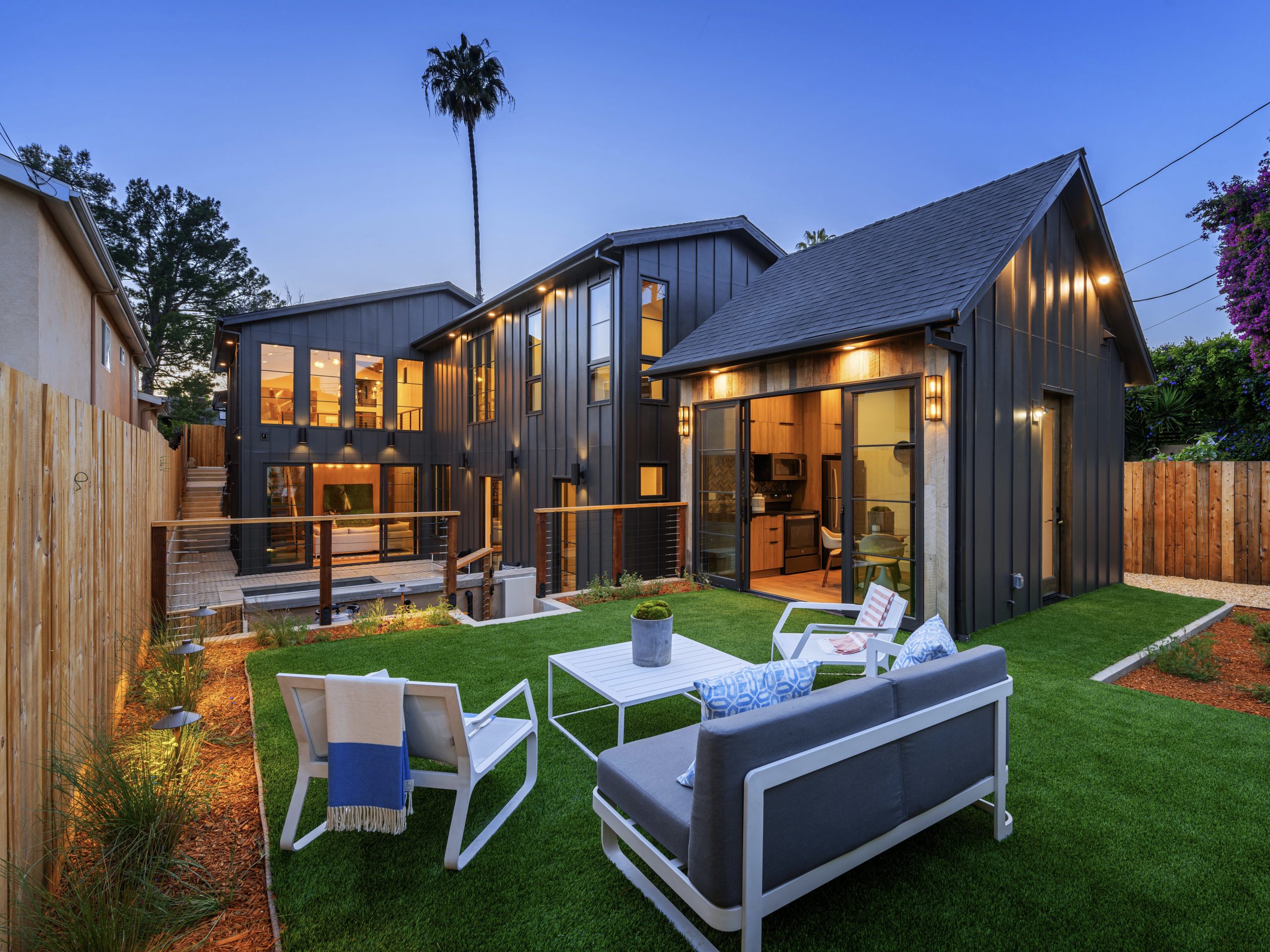 backyard-with-stylish-patio-furniture-a-lush-lawn-and-a-sleek-black-house-southern-california