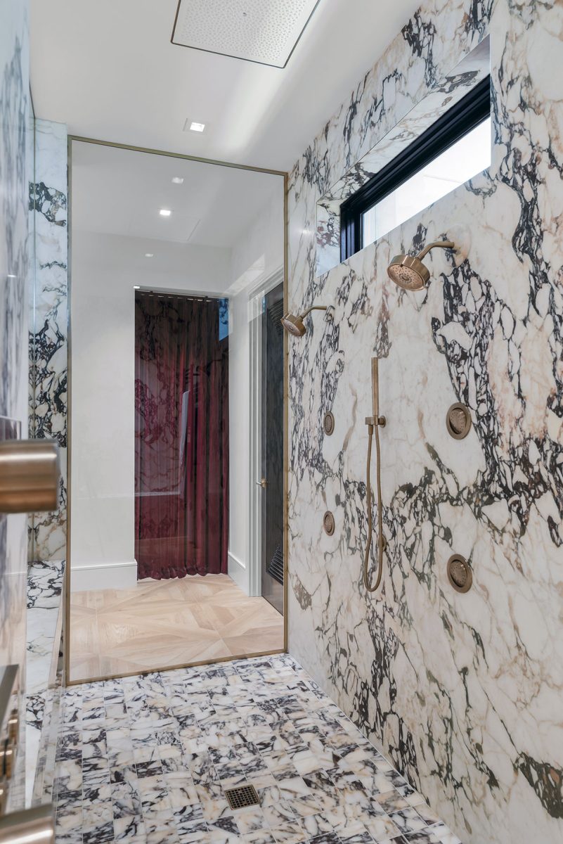 In the shower, multiple slabs of marble envelop the homeowners in the stone's bold veining and natural variation.