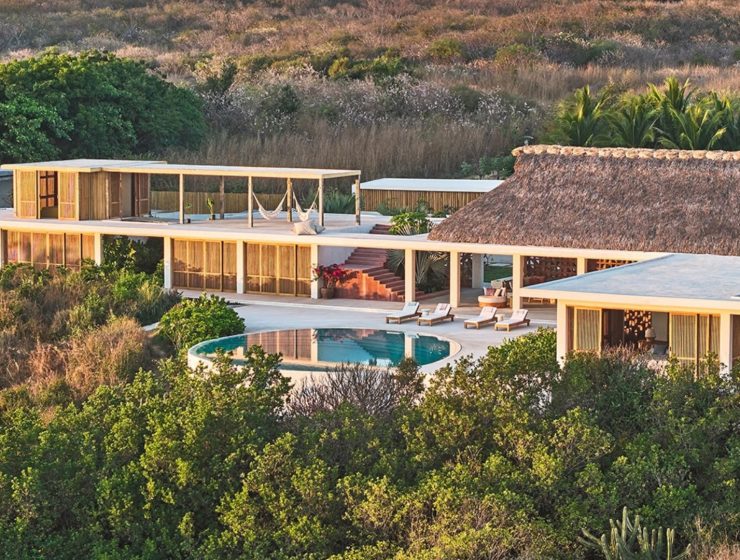 Aerial view of Casa Maya, a palapa-roofed house with a pool by Meyer Davis on the coast of Oaxaca, Mexico